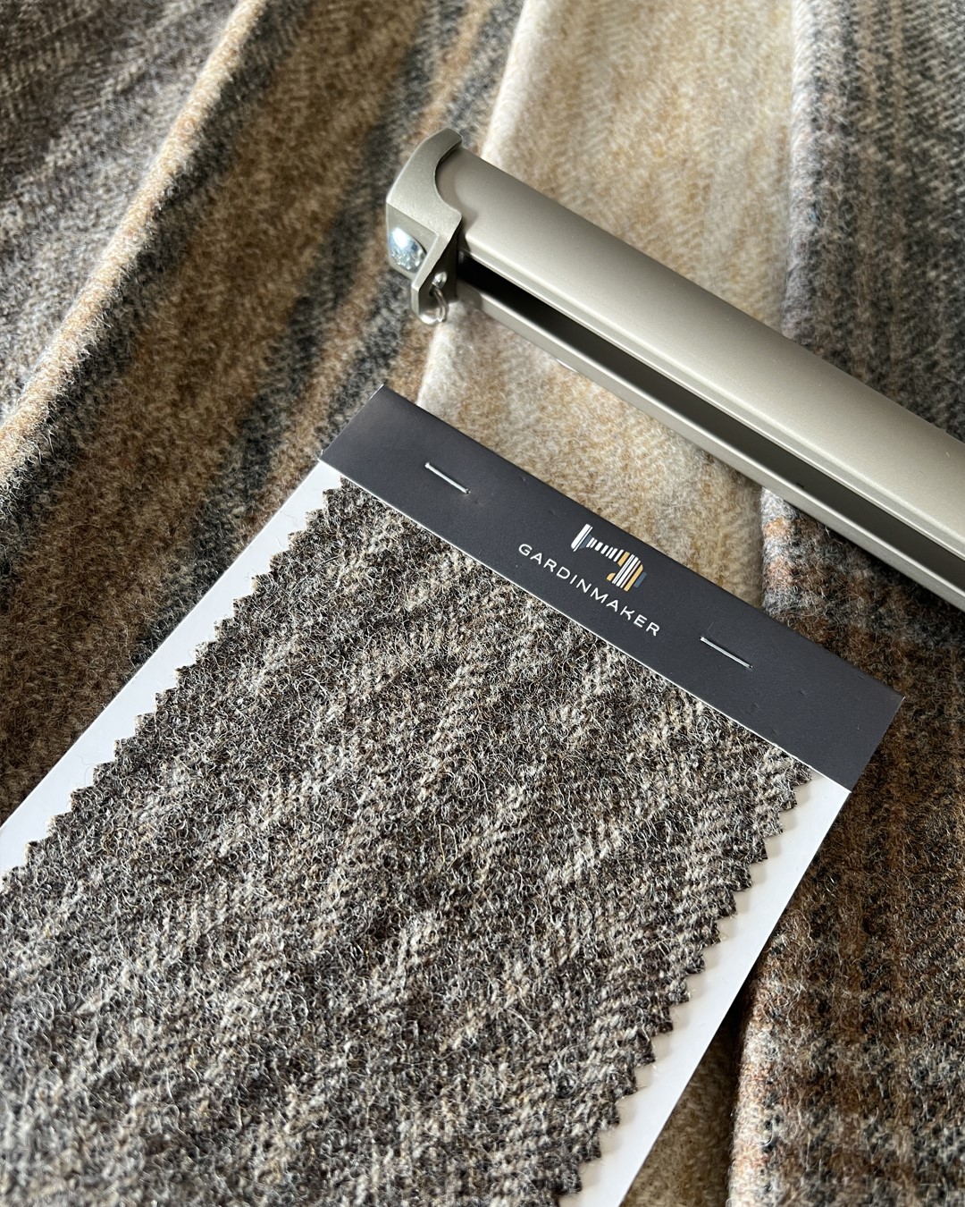 Tekstilprøve av tekstilen Naturally Moon II fra Moon i fargen Kintail Shale og Nexty gardinskinne i fargen Champagne. Gardinmaker.no. Foto. Tekstilprøve av tekstilen Naturally Moon II fra Moon i fargen Kintail Shale og Nexty gardinskinne i fargen Champagne. Gardinmaker.no. Foto.