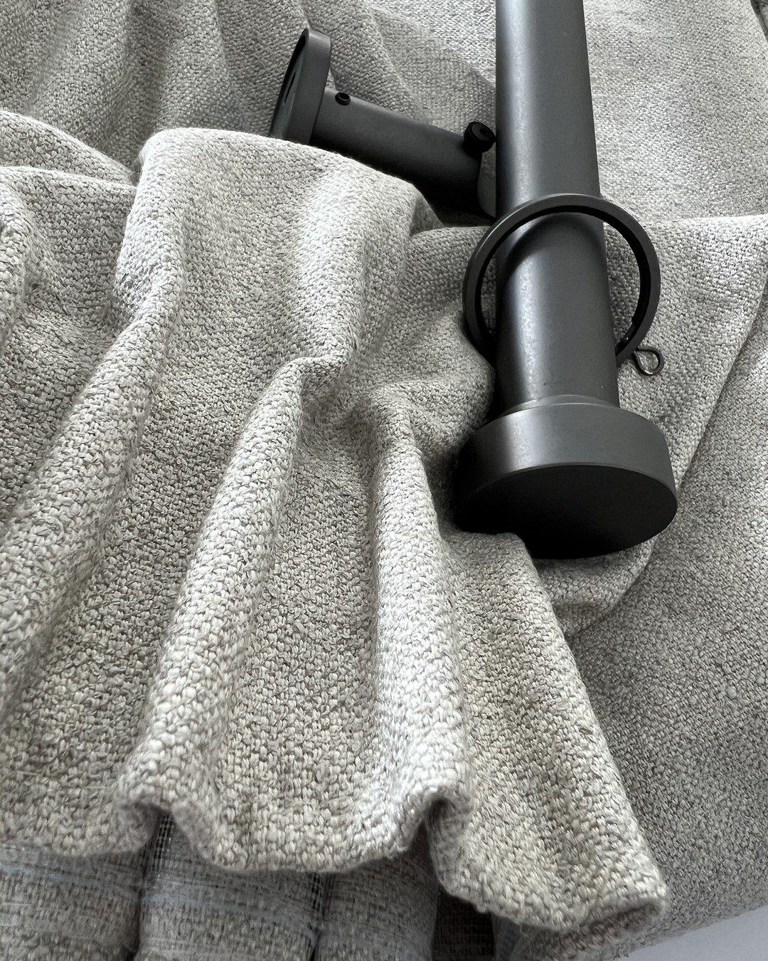 Detaljbilde av blyantfold. Skreddersydd gardin i tekstilen Kyri fra Roma, i fargen Taupe. Madison gardinstang i fargen Matt Graphite. Fra sømstudio hos Gardinmaker.no. Foto. Detaljbilde av blyantfold. Skreddersydd gardin i tekstilen Kyri fra Roma, i fargen Taupe. Madison gardinstang i fargen Matt Graphite. Fra sømstudio hos Gardinmaker.no. Foto.