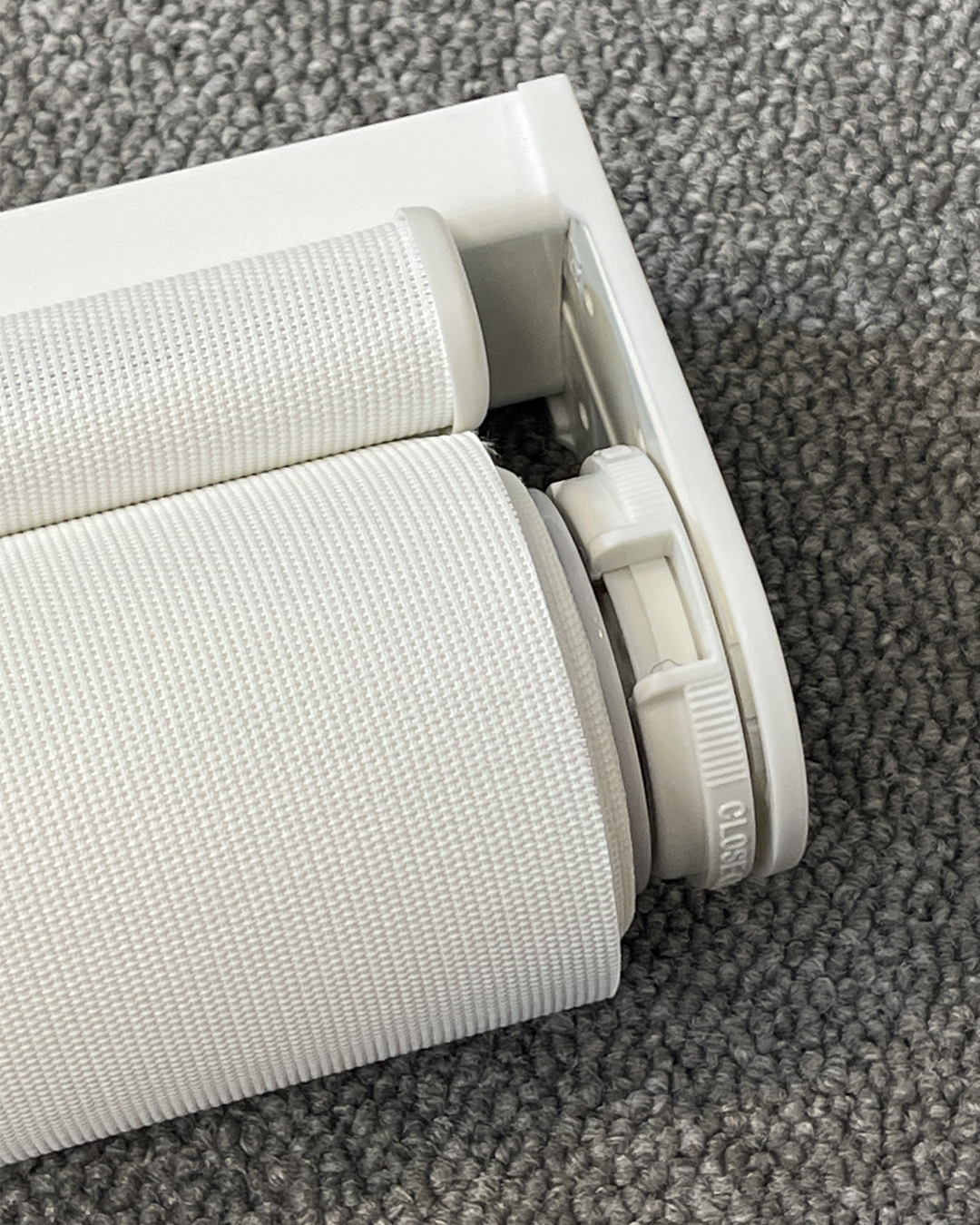 Detaljbilde av rullegardin med Toso system. Hvitt system med Screen Vision 5% fra Mermet i fargen White Linen. Foto.