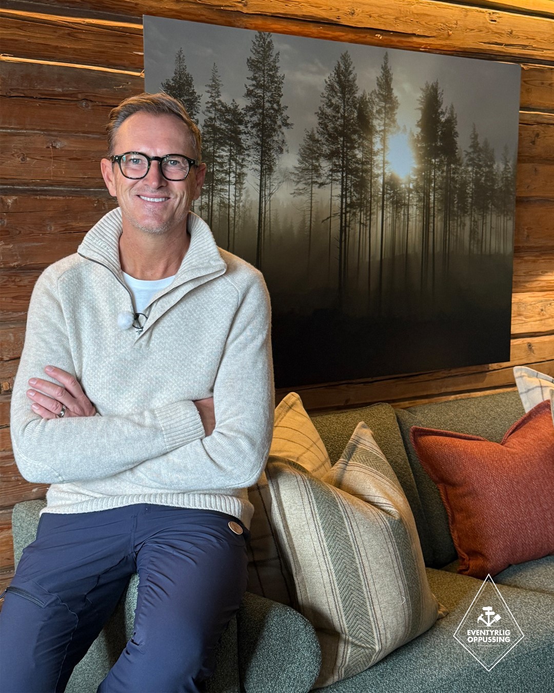 Halvor Bakke sitter i den grønne sofaen i stua i Mesnali, med puter i mønstret ulltekstil som matcher gardinene og binder sammen fargene i interiøret. Fra Eventyrlig Oppussing Mesnali. Foto.
