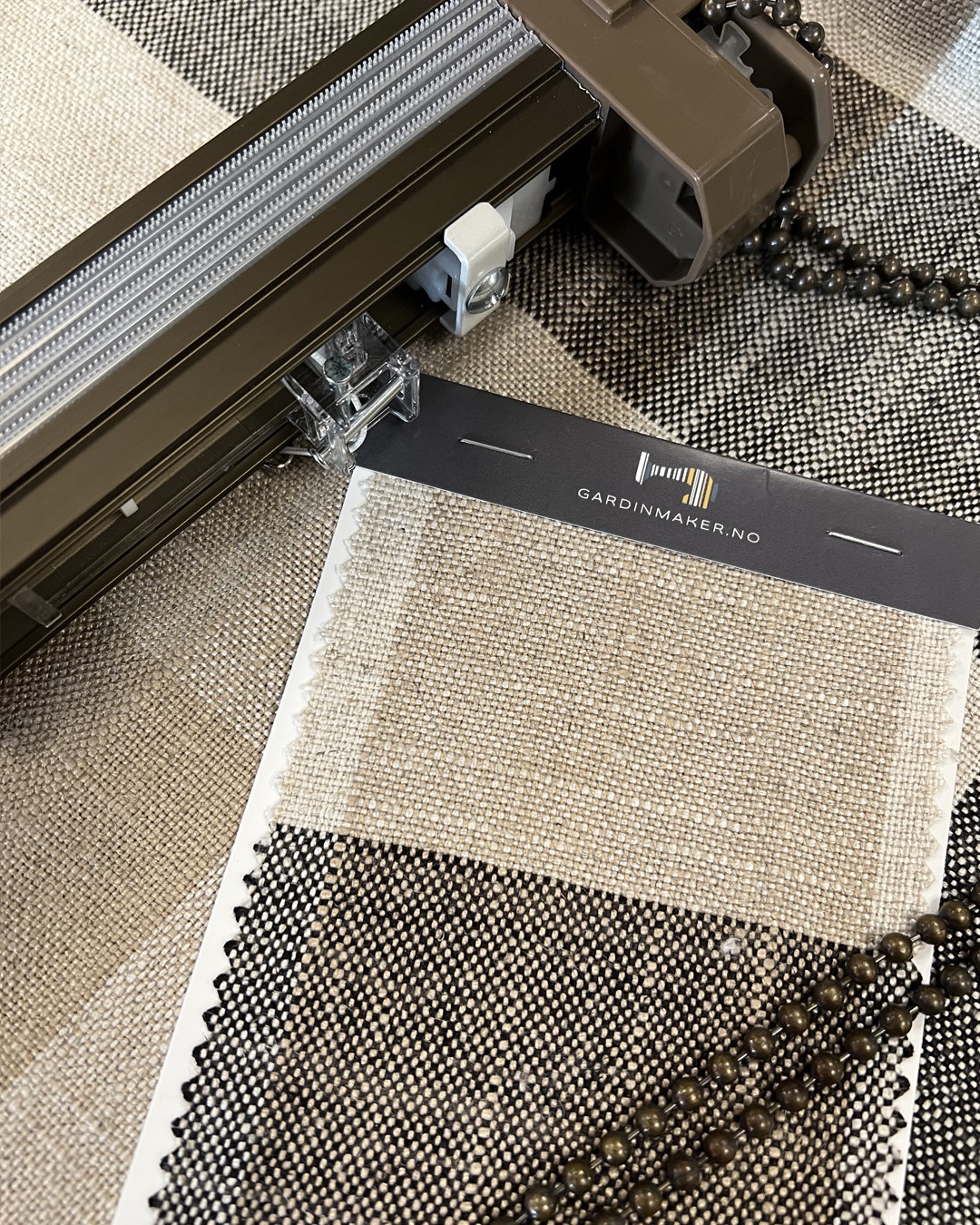 Detaljbilde av tekstilen Oban Check fra Ian Mankin i fargen Charcoal og Toso-liftsystem i fargen brun. Foto. Detaljbilde av tekstilen Oban Check fra Ian Mankin i fargen Charcoal og Toso-liftsystem i fargen brun. Foto.