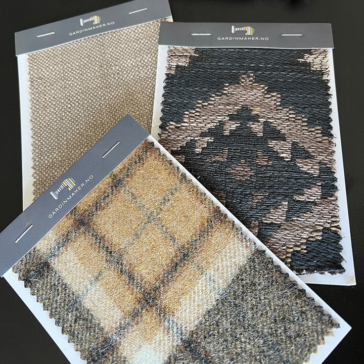 Tekstilprøver fra Gardinmaker.no med ulike farger og mønster og en Nexty gardinskinne i fargen Medium Eik. Foto.