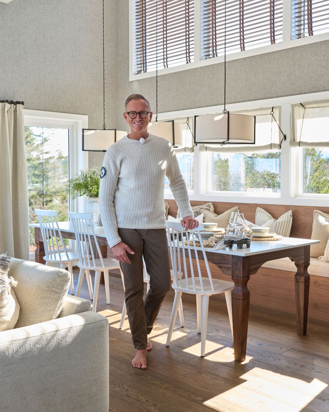 Halvor Bakke i spisestuen i Hamptons-stil på Tustna, med trepersienner i valnøtt og 1700-talls liftgardiner i lin over sittebenken.
