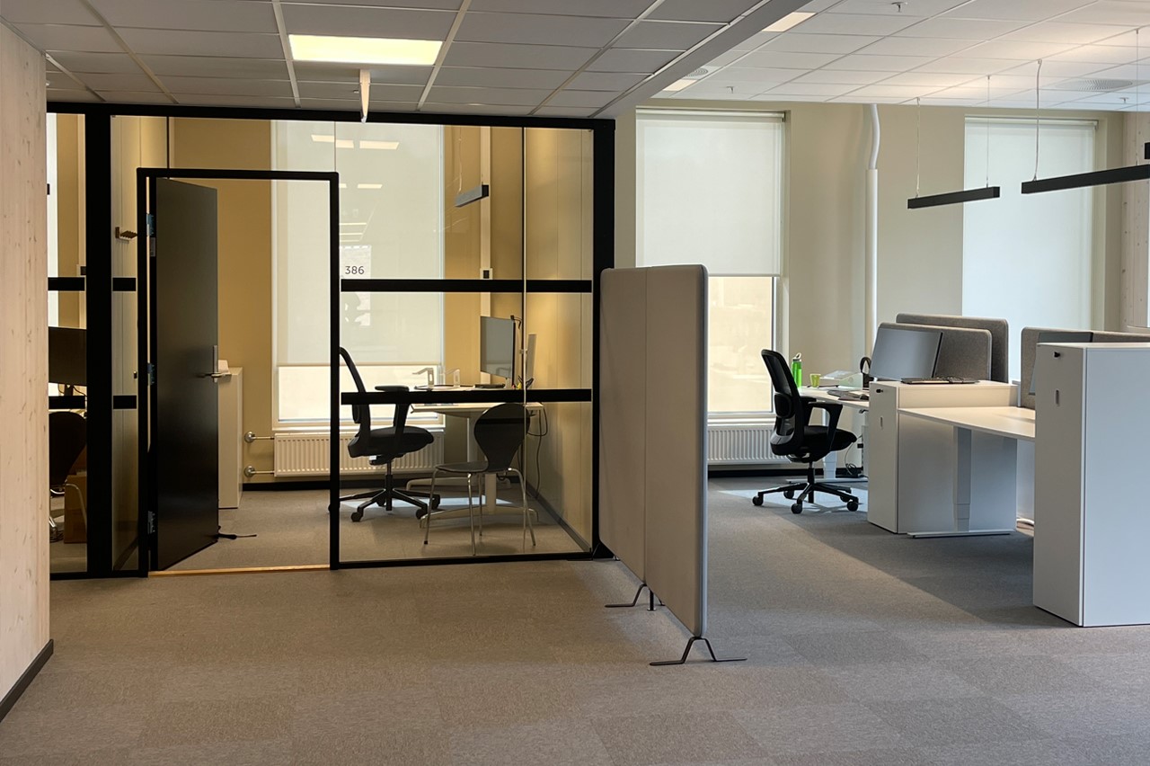 Moderne kontor i lys beige vegger med hvit kontorpult og sort stor. Vindu med rullegardin Screen Vision 5% fra Mermet i fargen White Linen. Foto. Moderne kontor i lys beige vegger med hvit kontorpult og sort stor. Vindu med rullegardin Screen Vision 5% fra Mermet i fargen White Linen. Foto.